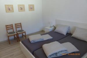 a bedroom with a bed with two pillows and a chair at Haus am Bach in Fulpmes