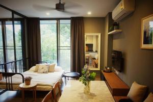 Live Your Dream Khaoyai في Phayayen: غرفة معيشة مع أريكة وطاولة
