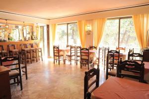 a restaurant with a dining room with tables and chairs at The Delfini Hotel in Agia Marina Aegina