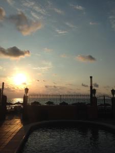 a sunset over a pool with the ocean in the background at Lloyds Beach Club in Torrevieja