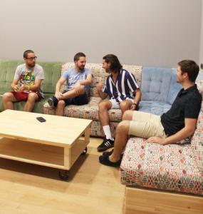 people sitting on couches in a living room at Welcome Hostel in Churriana
