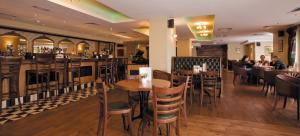 un restaurante con mesas y sillas de madera y un bar en Ard Ri House Hotel en Tuam