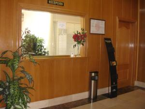 un pasillo del hospital con una ventana y un cubo de basura en Hostal Serpol en Palencia