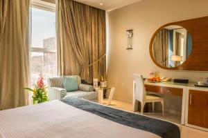 a hotel room with a bed and a desk and a mirror at Al Muhaidb Residence Al Malaz 2 in Riyadh +35 photos