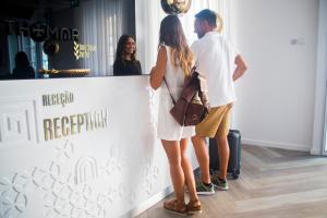 a man and a woman standing next to a wall at Thomar Boutique Hotel in Tomar