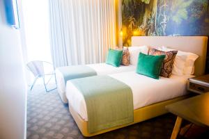 a hotel room with two beds and two lamps at Thomar Boutique Hotel in Tomar