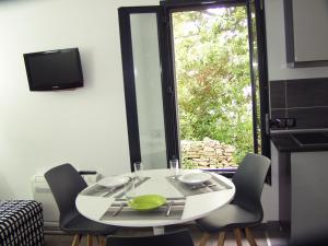 a table and chairs in a room with a window at Gîte La Capitelle in Boissières