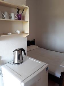 a tea kettle sitting on top of a counter next to a bed at Villa Magdalena studios in Ágios Ioánnis
