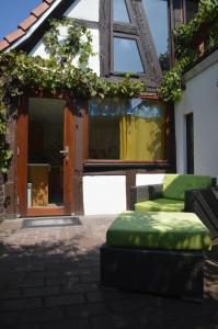 un patio con reposapiés verde frente a un edificio en Ferienwohnungen Treiber, en Eggenstein-Leopoldshafen