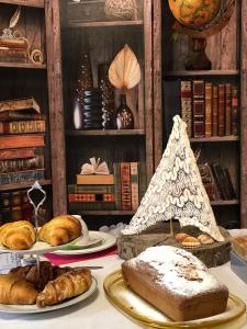 una mesa con platos de pan y bollería. en Al Chiaro di Luna, en Paternopoli