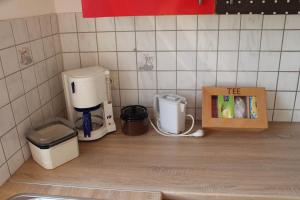 a kitchen counter with a coffee maker and a box at Ferienwohnung Tropical in Vendersheim