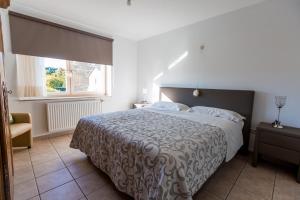 ein Schlafzimmer mit einem großen Bett und einem Fenster in der Unterkunft Casa Roman - nieuwe vakantiewoning - Deluxe 4p - Relax 4p - Comfort 4p -- ---Cosy 2p in Zonhoven