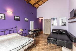 Schlafzimmer mit lila Wänden, einem Bett und einem Tisch in der Unterkunft Malatesta Antica Dimora in Longiano