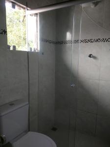un bagno con wc e doccia in vetro di Ubatuba Suites Itamambuca a Ubatuba Altre 51 foto