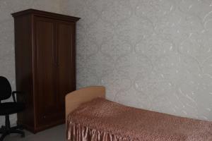 オレンブルクにあるHotel Krasnaya gorkaのベッドルーム1室(ドレッサー、ベッド1台、キャビネット付)