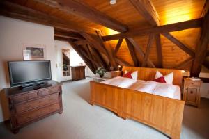 a large bedroom with a large bed and a flat screen tv at Altstadthotel Bad Griesbach in Bad Griesbach