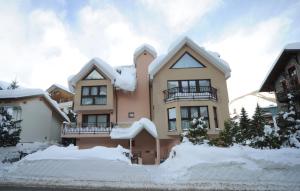 una casa cubierta de nieve con nieve alrededor en Residence Villa Frejus, en Bardonecchia