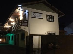 un edificio blanco con un cartel en él por la noche en Pousada Villa Garcia - Residencial, en Florianópolis