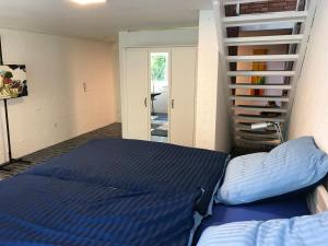 1 dormitorio con 1 cama y escalera de caracol en Ferienhaus Atelier am Südhang, en Worpswede