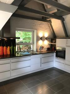 a large kitchen with white cabinets and a window at Ferienhaus Atelier am Südhang in Worpswede