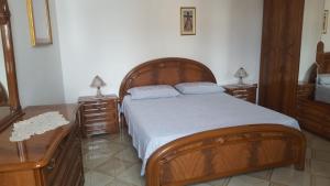 ガラトーネにあるAbitazioneのベッドルーム1室(木製ベッド1台、ドレッサー2台、テーブル2台付)