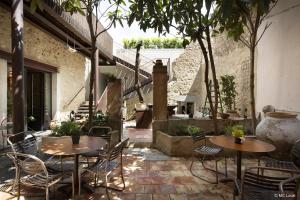 an outdoor patio with tables and chairs and stairs at Le 19-21 - Un amour d'hotel in Leucate