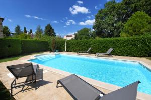 a swimming pool with two chairs and a table at Villa Svetlana in Vabriga