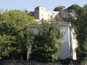 a white garage with a castle in the background at Gîte Les Clapas in Boissières
