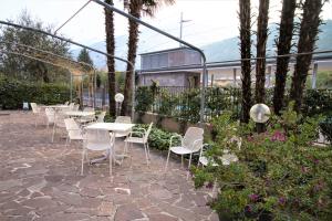 una fila de mesas y sillas en un jardín en Villa Orchidea, en Nago-Torbole