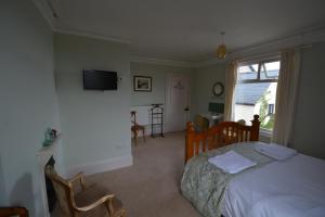 a bedroom with a bed and a tv on the wall at Severn House in Watchet