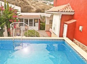 a large blue swimming pool next to a house at Casa Buganvilla in Los Realejos