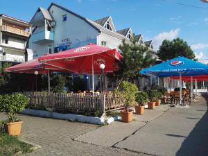 um restaurante com guarda-sóis e mesas vermelhos e azuis em Apartment Agmashenebeli 99 em Kobuleti