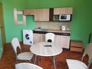 a kitchen with a table and chairs and a microwave at Hotel Erfolg in Daugavpils