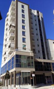 a large white building with windows on a street at Rezidenca SHOPI in Elbasan