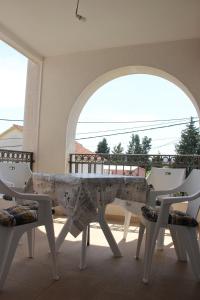 - Balcón con mesa blanca y sillas en Apartments Durutović, en Bar