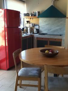 a kitchen with a wooden table and a red refrigerator at The Dina Palace. in Villefranche-sur-Mer