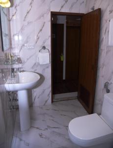 La salle de bains blanche est pourvue d'un lavabo et de toilettes. dans l'établissement Kailash Kuti Inn, à Katmandou