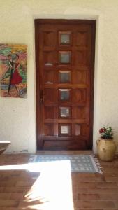 a wooden door of a house with a plant next to it at Grand Studio Entre Lac Et Garrigue in Clermont-lʼHérault