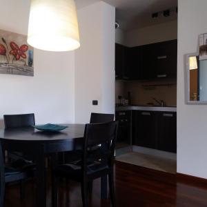 uma cozinha com uma mesa e cadeiras e um candeeiro em Milano Greco appartamento em Milão