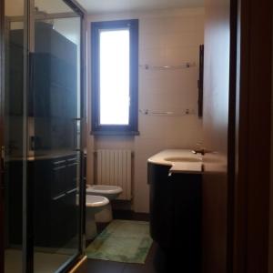 uma casa de banho com um WC, um lavatório e uma janela em Milano Greco appartamento em Milão