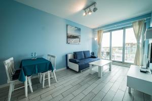 a blue living room with a blue couch and a table at Wechta E5 in Międzyzdroje
