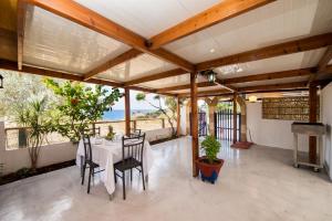 jadalnia ze stołem i krzesłami na patio w obiekcie Stegna Paradise View w mieście Archangelos