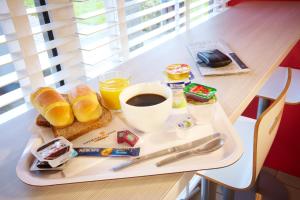 een dienblad met ontbijtproducten en koffie op een tafel bij Premiere Classe Strasbourg Ouest in Straatsburg