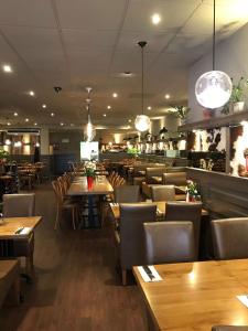 a restaurant with wooden tables and chairs and lights at Hotel Manofa in Amsterdam