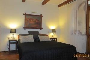 a bedroom with a black bed and two lamps at Apartment Irena in Sveti Stefan