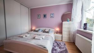 ミエンジズドロイェにあるBłękitny 47のピンクの壁のベッドルーム1室(大型ベッド1台付)