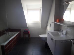 a bathroom with a tub and a toilet and a sink at Les Gîtes de la tour, appartement "le Vignoble" in Saint-Hippolyte +21 photos