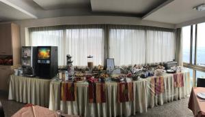 a long table with food on it in a room withwindows at Hotel Cosmomare in Piano di Sorrento