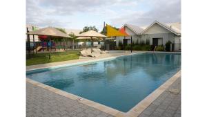 una piscina con sillas y sombrillas junto a una casa en FortyTwo - Oceanside Retreat Busselton en Busselton