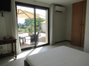 una camera da letto con porta che si apre su un patio di Le Bastidon de CUCURON a Cucuron